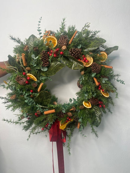 Corona con naranjitas, piñones, canela y berries rojos, de 19